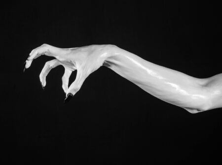 white hands of death with black nails, white death, the devil's hands, the hands of a demon, white skin, halloween theme, black background, isolated studioの写真素材
