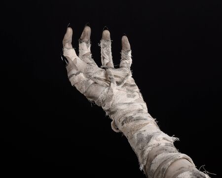 Halloween theme: terrible old mummy hands on a black backgroundの写真素材