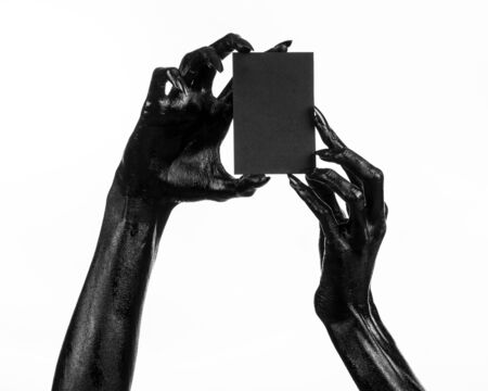 Halloween and gothic theme: The Black Hand of death holding a blank black card on white isolated background in the studio, the walking deadの写真素材