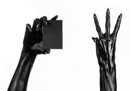 Halloween and gothic theme: The Black Hand of death holding a blank black card on white isolated background in the studio, the walking deadの写真素材