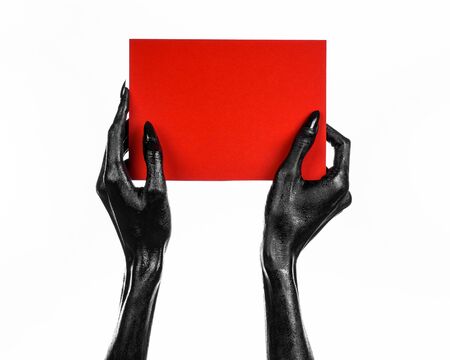 Halloween and gothic theme: The Black Hand of death holding a blank red card isolated on a white background in the studio, the walking dead shotの写真素材
