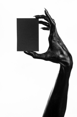 Halloween and gothic theme: The Black Hand of death holding a blank black card on white isolated background in the studio, the walking deadの写真素材