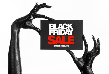 Black Friday theme: black hand holding a card with discount on white background studioの写真素材