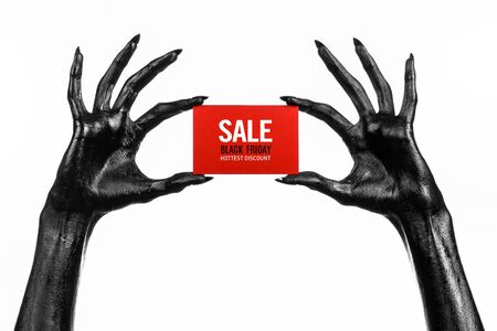 Black Friday theme: black hand holding a red card for a discount on white background studioの写真素材