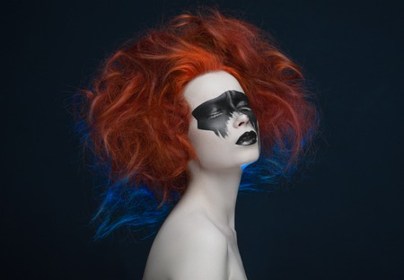 Makeup mask red hair girl in studioの写真素材