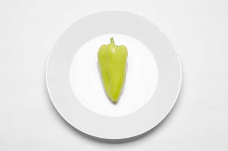 Healthy eating in the restaurant and diet Topic: beautiful ripe green pepper on a white plate lie on white table isolated studio top view studioの写真素材