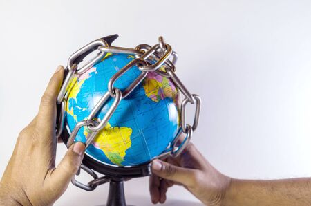 Conceptual chaining and protecting world globe holding hand idea isolated in whiteの写真素材