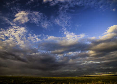 grass field dramatic sky and clouds at sunset  sunrise の写真素材