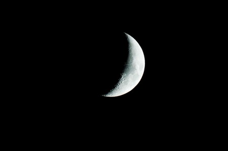 glowing crescent moon on black sky backgroundの写真素材
