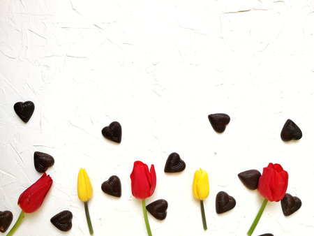 different flowers , tulips and chrysanthemums with chocolates in the shape of a heart and an...