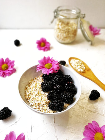 oatmeal with blackberries and flowers on a white background