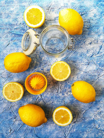 whole and sliced lemon with blackboard on blue background with yellow napkinの写真素材