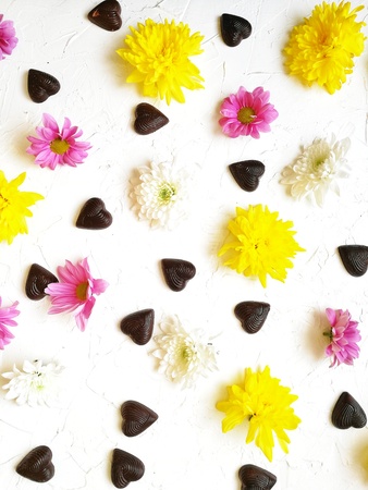 different flowers , tulips and chrysanthemums with chocolates in the shape of a heart and an envelope to writeの写真素材