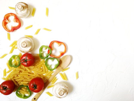 raw pasta with a variety of vegetables on white backgroundの写真素材