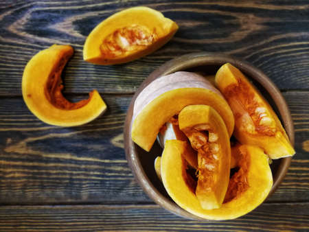 sliced pumpkin with a knife on a wooden Board and the old backgroundの写真素材
