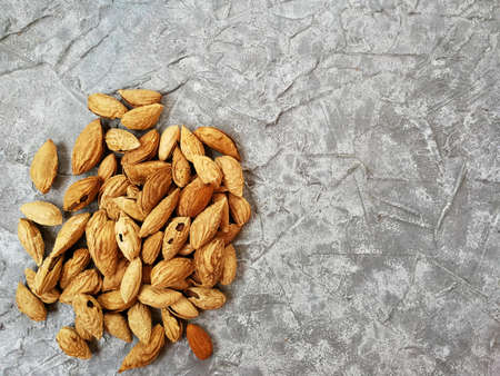 walnut almonds peeled and in-shell on a gray backgroundの写真素材