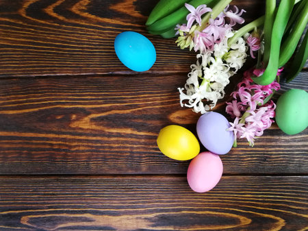 painted eggs for the spring holiday of Easter with hyacinths on a wooden textured background