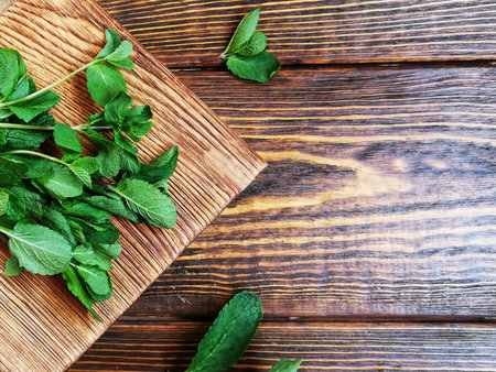 Bunch of mint on brown wooden chopping Board on wooden background