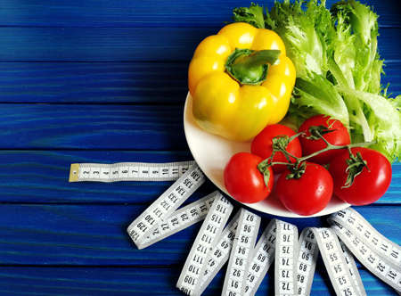 variety of vegetables with measuring tape on wooden backgroundの写真素材