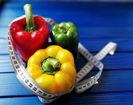 edfmulticolored Bulgarian peppers with measuring tape on blue background