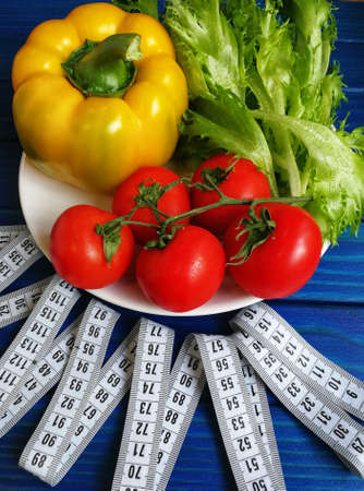 variety of vegetables with measuring tape on wooden backgroundの写真素材
