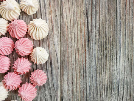 the airy meringue white and pink lies on a light Desk in rows and columnsの写真素材