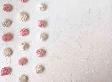 the airy meringue white and pink lies on a light Desk in rows and columnsの写真素材