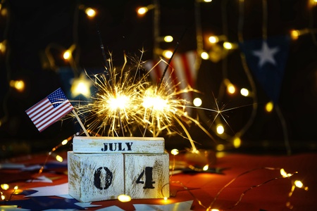 Ruffled American flag and wooden cube calendar with 4th of July, USA Independence Day date, copy space celebratory background. US patriotic festive composition, close up, concept, holiday, patriotism, fun and freedomの写真素材