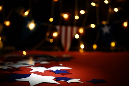 Fireworks display celebrates the independence Day of the United States of America nation on the fourth of July with the us flag , sparklers , candy, on the red background and on the background of Christmas garland and bokeh, with the stars , the end of the Celebration of freedom.の写真素材