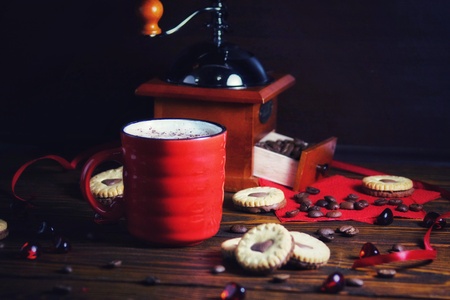 Valentines day heart shaped cookies and red coffee cup. View from above over white wooden tableの写真素材