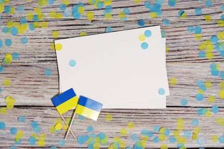 24 August independence Day of Ukraine the concept of the Day of memory of freedom and patriotism. Mini flags with paper confetti on wooden white background.の写真素材