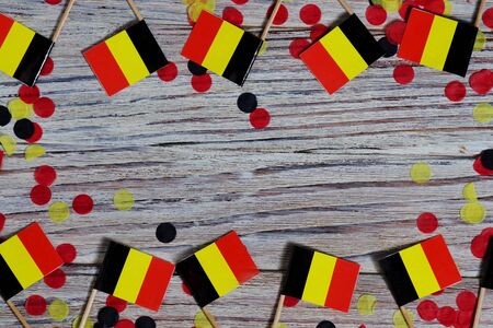 Flag of Belgium hanging on clothesline attached with wooden clothespins on white wooden background. National day concept.の写真素材