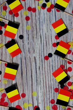 Flag of Belgium hanging on clothesline attached with wooden clothespins on white wooden background. National day concept.の写真素材
