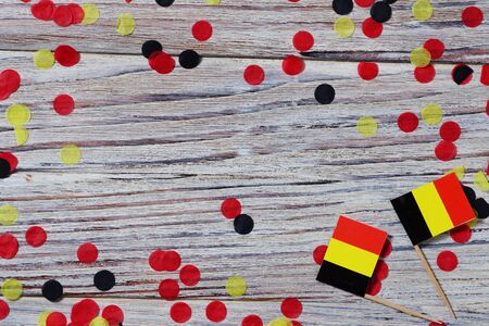 Flag of Belgium hanging on clothesline attached with wooden clothespins on white wooden background. National day concept.の写真素材