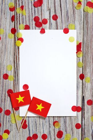 Independence Day of Vietnam concept with flag in hand on white wooden background top viewの写真素材
