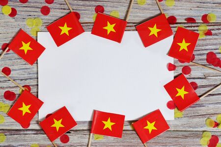 Independence Day of Vietnam concept with flag in hand on white wooden background top viewの写真素材