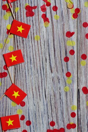 Independence Day of Vietnam concept with flag in hand on white wooden background top viewの写真素材