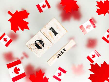 July 1, Happy Canada Day. Red maple leaves, flags and a wooden calendar on a transparent foggy background. The concept of freedom and patriotism, independence and victory. High quality photoの写真素材