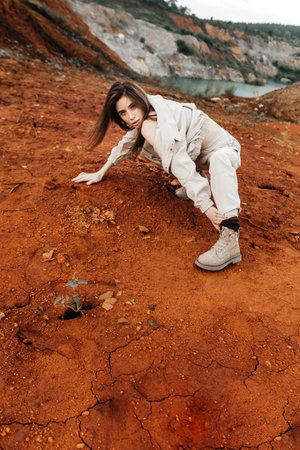 Girls in a post-apocalyptic place, a quarry with red earth and stones in work clothes. high quality...
