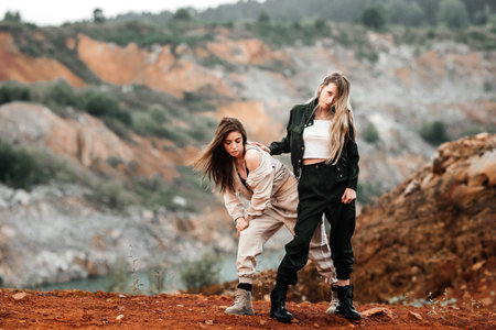 Girls in a post-apocalyptic place, a quarry with red earth and stones in work clothes. high quality...