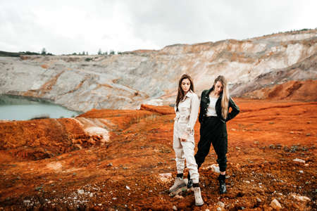 Girls in a post-apocalyptic place, a quarry with red earth and stones in work clothes. high quality photoの写真素材