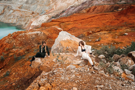 Girls in a post-apocalyptic place, a quarry with red earth and stones in work clothes. high quality...
