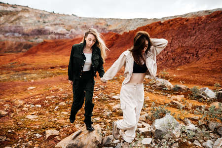 Girls in a post-apocalyptic place, a quarry with red earth and stones in work clothes. high quality photoの写真素材