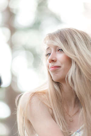 Blonde girl in a light airy dress, barefoot at dawn in a summer forest. high quality photoの写真素材
