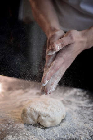 hands of the cook kneading pizza dough close-upの写真素材