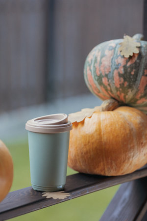 Autumn coffee with yellow oak leaves, in a glass against a background of pumpkins. high quality photoの写真素材