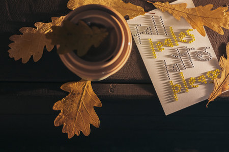 autumn coffee in a mug with pumpkins and oak leaves, on the background of the phrase from...