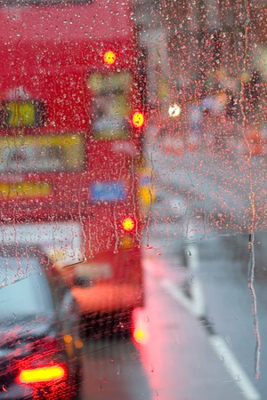 Rain in London view to red bus through rain-specked windowの写真素材