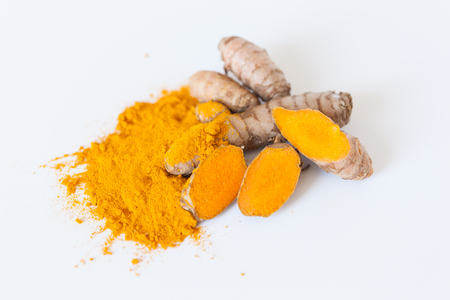 Turmeric roots with turmeric powder isolated on white backgroundの写真素材