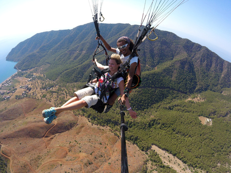 ADRASAN, TURKEY - JUNE 27, 2017: Paraglaiding fly above lagunaのeditorial素材